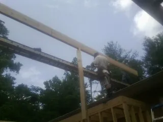 Carpenter setting a ridge beam over a new addition frame — Ice Dam Removal by Roofing Brothers in Novato