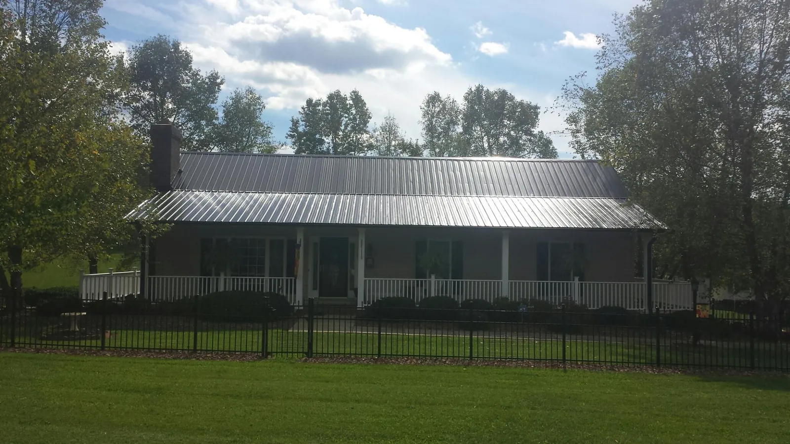 Gray metal roof on a brick ranch with a full width front porch — Gutter Guard Installation work by our crew in Novato